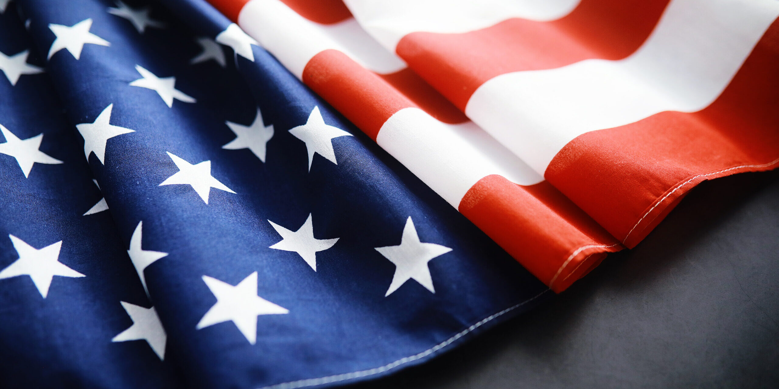 Flapping flag USA with wave. American flag for Memorial Day or 4th of July. Closeup of American flag on dark background